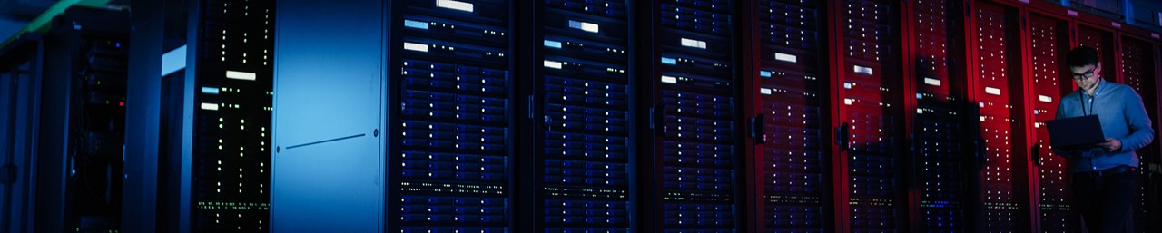 データセンタールームでノートパソコンを使って働く男性