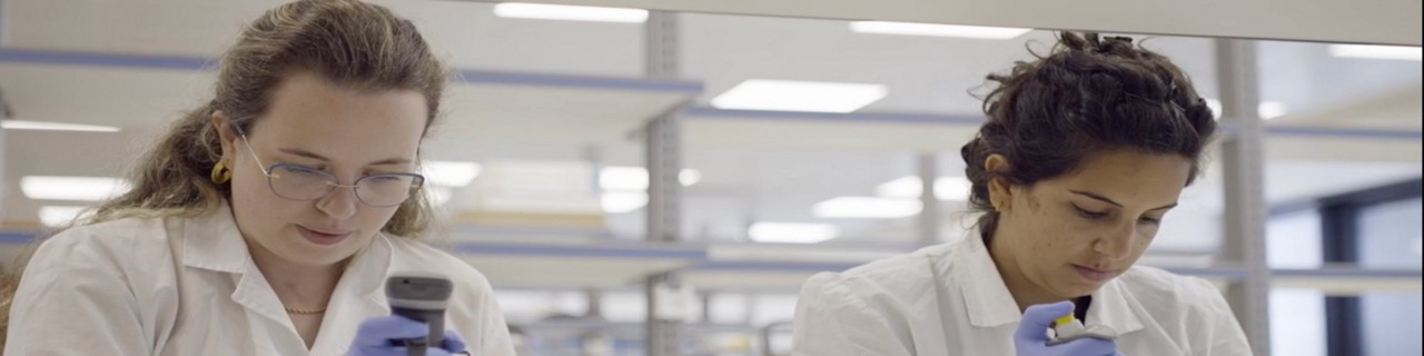 ventures-blog-hero-2000x500.jpg：ラボ用の白衣を着た2人の女性、1人は顕微鏡を手にしている