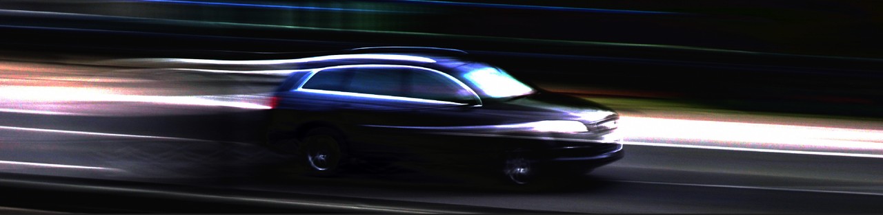 夜間の道路を走行している自動車