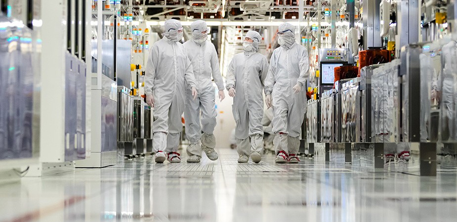 清潔な作業着を着て製造工場の廊下を歩いている作業員たち