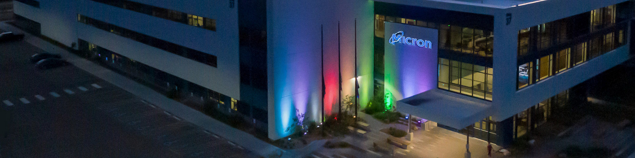 レインボーカラーにライトアップされた夜のマイクロン社屋